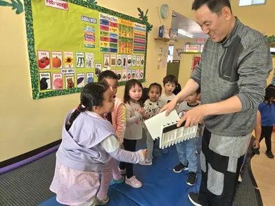 Child doing a Tae Kwon Do activity with the lecturer breaking a board at Newport Ave Preschool enrichment program