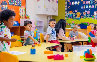 3-year-old children in Newport Ave Preschool's Junior Pre-K program playing with colorful building bricks in a collaborative activity